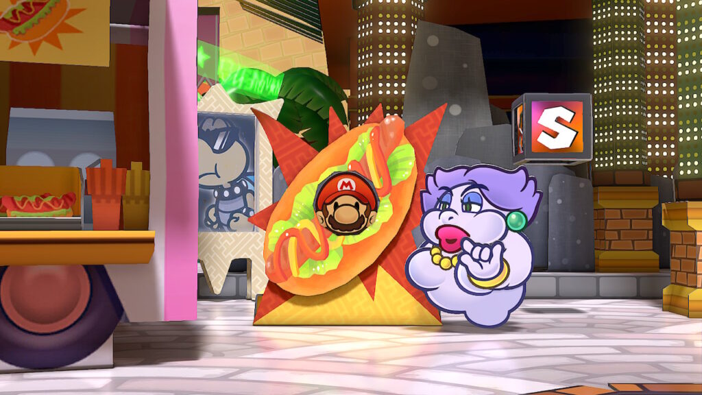 Paper Mario prend la pose derrière un panneau en carton avec un trou pour la tête